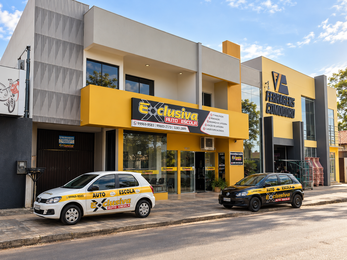 Fachada amarela da Auto Escola Exclusiva na Rua Espírito Santo, ao lado da Ferragens Comodoro, no centro de Comodoro